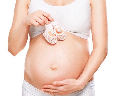 pregnant belly with baby shoes